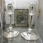A pair of tall silver candlesticks on oval bases