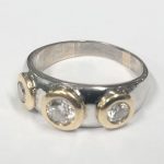 An 18ct yellow & white gold ring set round brilliant cut diamonds